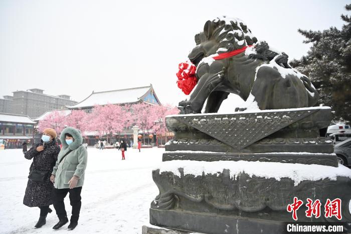 2月13日，民眾在呼和浩特市大召廣場(chǎng)雪中漫步?！⑽娜A 攝