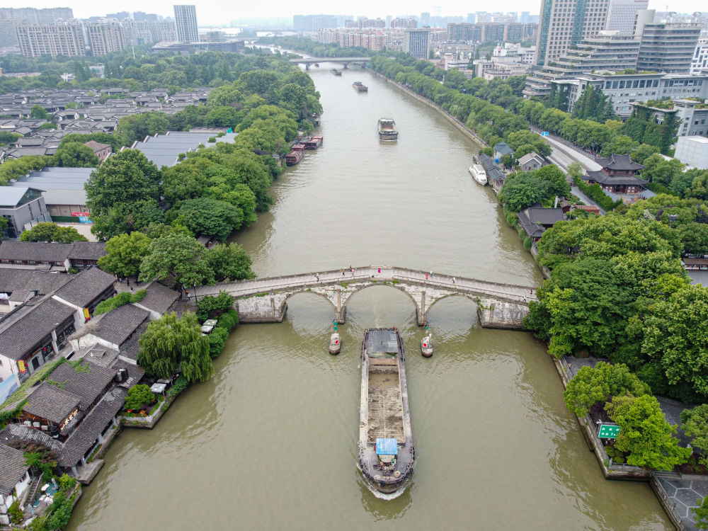 5月27日，一艘貨船駛過京杭大運河南端標志建筑杭州拱宸橋。(無人機照片)新華社記者江漢 攝