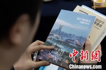 參展觀眾閱讀浙江文旅手冊(cè)?！《≌裾?攝