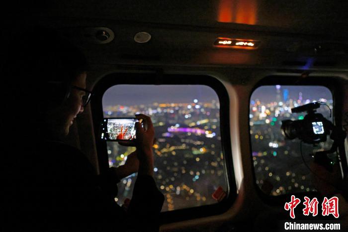 6月3日晚，游客乘坐上海新空直升機有限公司直升機開啟鳥瞰黃浦江空中圓夢之旅，并用手機拍攝城市夜景。　殷立勤 攝