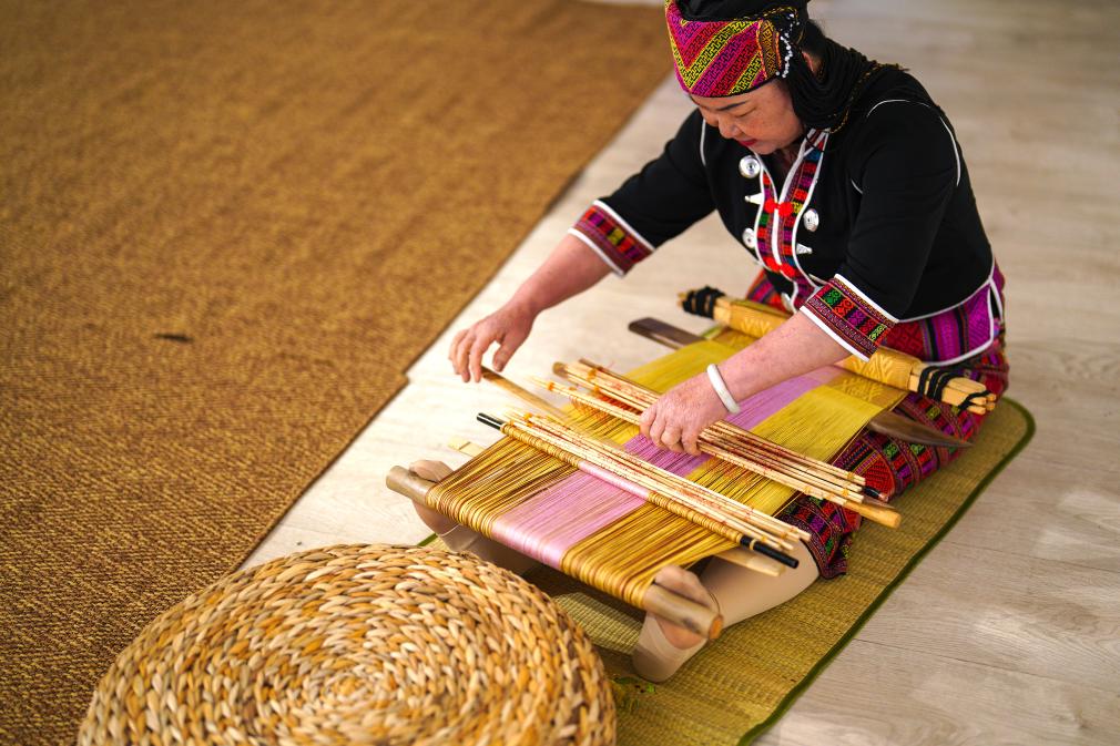 4月17日，黎族傳統(tǒng)紡染織繡技藝國家級代表性傳承人劉香蘭在2023年意大利米蘭設(shè)計周上展示黎錦織造技藝。新華社發(fā)