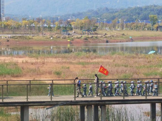 　　10月24日，秋游的幼兒園小朋友在老師帶領(lǐng)下走在清水塘公園里的木橋上。本報(bào)記者 常雯宜攝