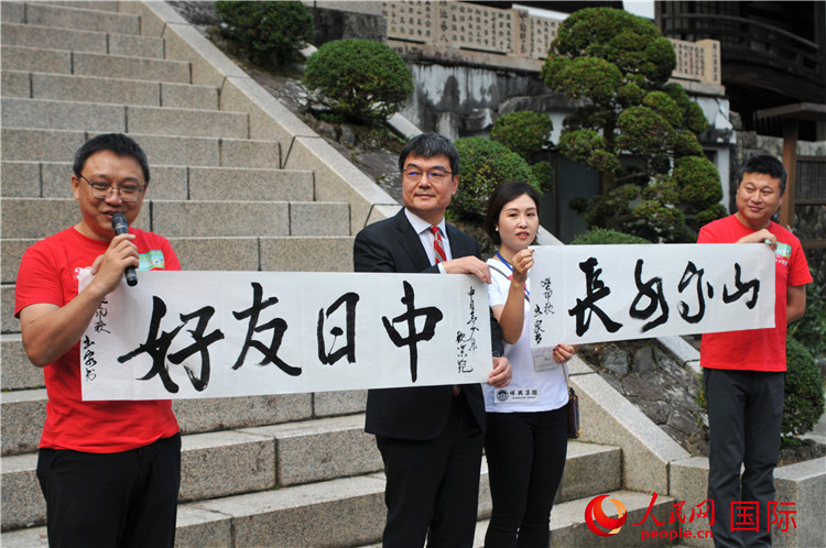 東京中國文化中心主任羅玉泉展示其為本次活動書寫的題詞“中日友好，山高水長”。人民網(wǎng) 蔣曉辰攝