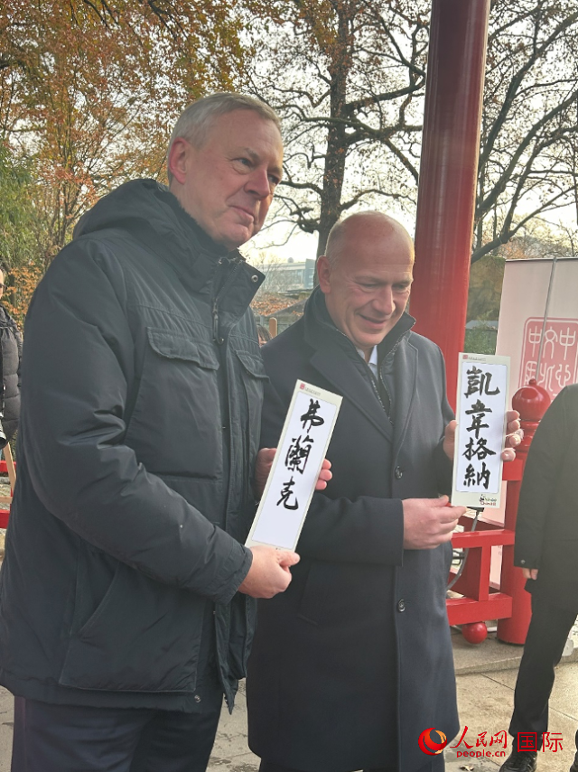 柏林市長韋格納（右）、動物園監(jiān)事會主席布魯克曼（左）手持中國文化中心工作人員現(xiàn)場手書的中文名字。人民網(wǎng)記者 徐馨攝