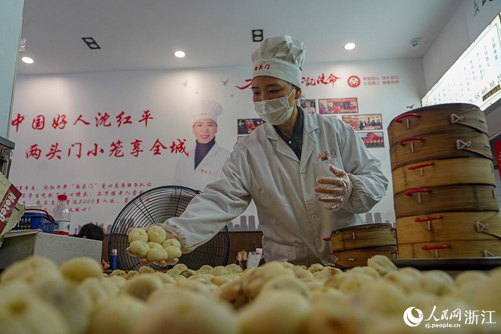 3月31日，在浙江省嵊州市甘霖鎮(zhèn)，嵊州小吃從業(yè)者沈紅平把蒸熟的小籠包晾涼，打包冷藏售賣。人民網(wǎng) 章勇濤攝