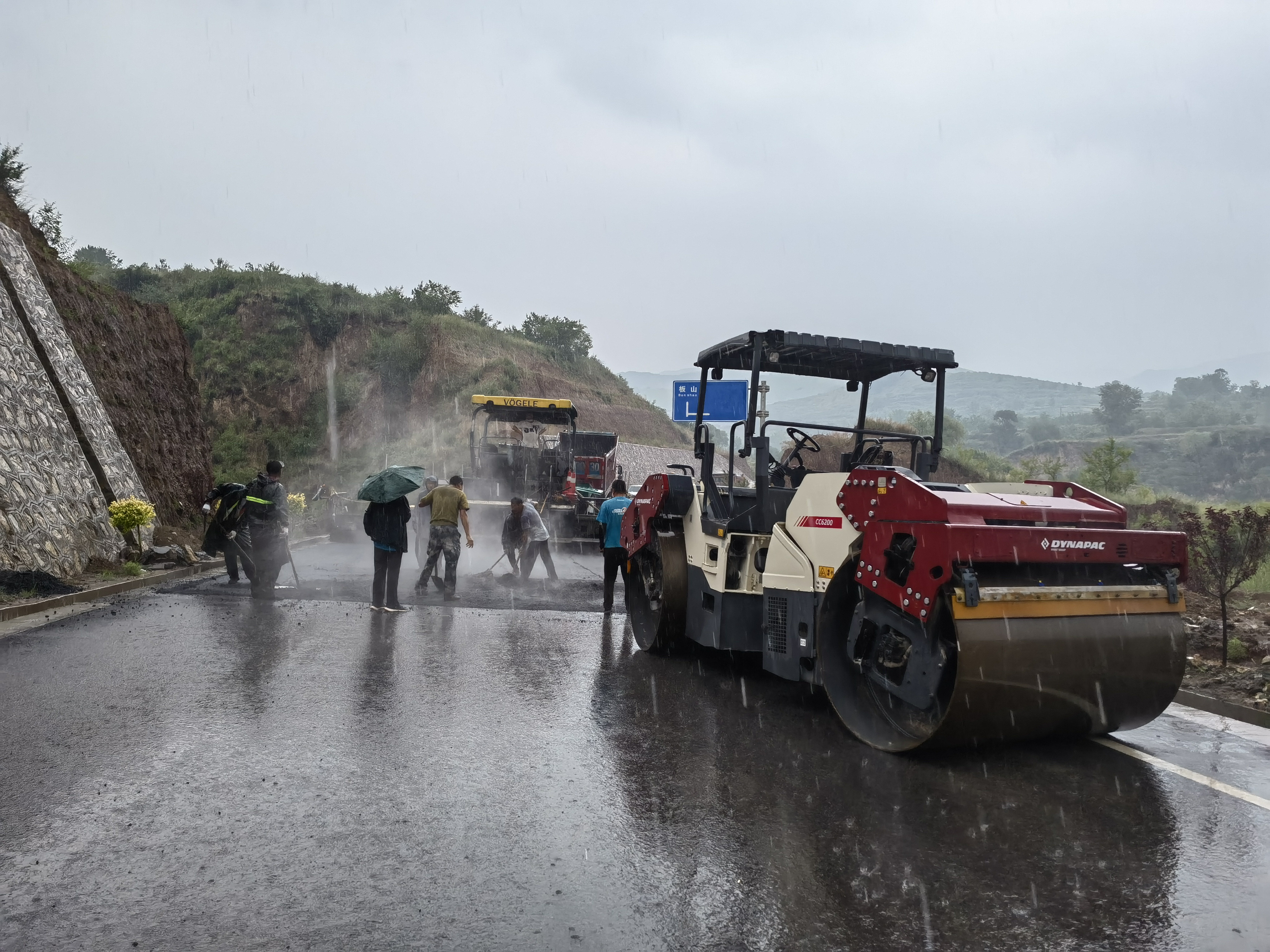 路橋工人在大雨中搶修道路。李華英 攝