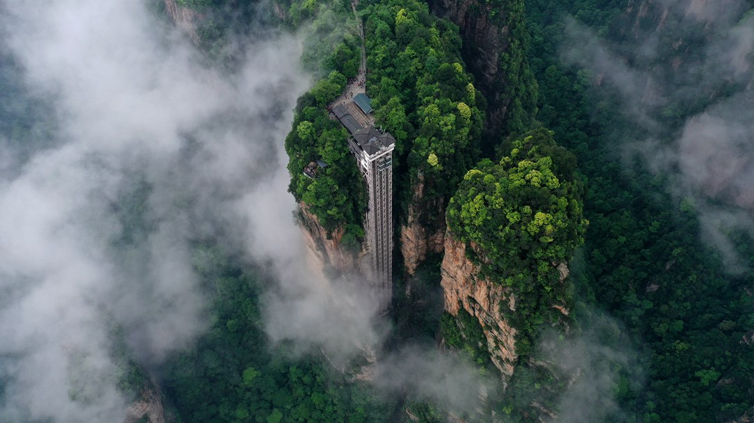 位于張家界武陵源景區(qū)的百龍?zhí)焯蓁偳对谠旗F繚繞的峰林間，雄偉壯觀。吳勇兵攝