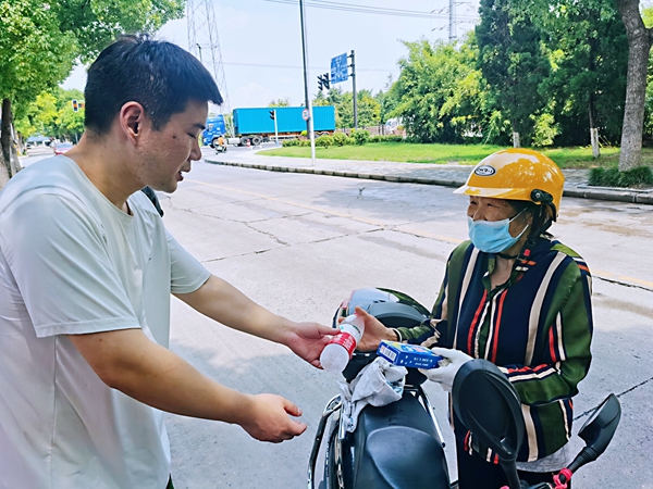 何超為過路的老人送上礦泉水和冷飲。人民網(wǎng)記者 王繼亮攝