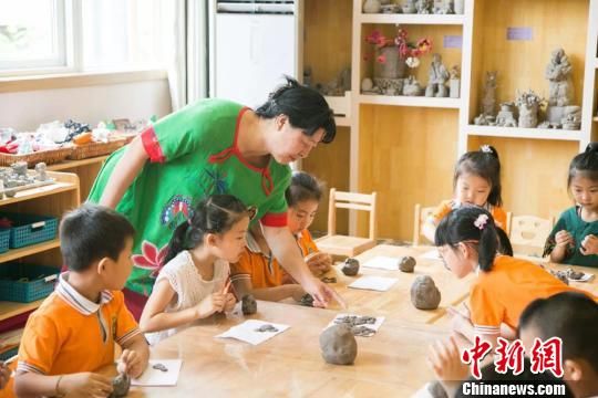 圖為劉雪玲正在給幼教中心的孩子上泥塑課?！＄娦?攝