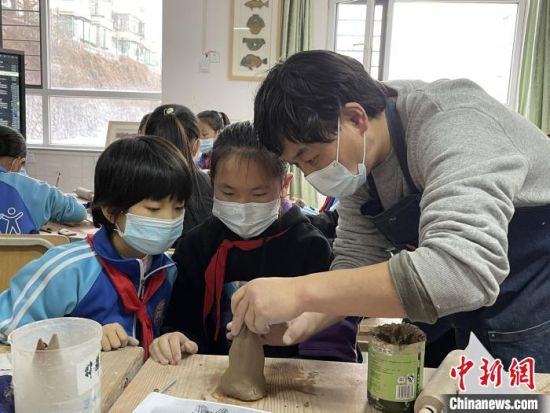 圖為西寧市勞動路小學(xué)教師賈煜與學(xué)生一起制作陶藝?！≈苋鸪阶?攝