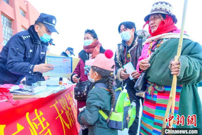 圖為拉薩鐵路公安民警向旅客發(fā)放乘車(chē)安全宣傳資料。　黃飛 攝