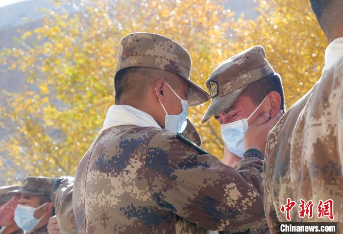 圖為什布奇邊防連退伍老兵與戰(zhàn)友相擁而泣，依依惜別。　徐昌成 攝