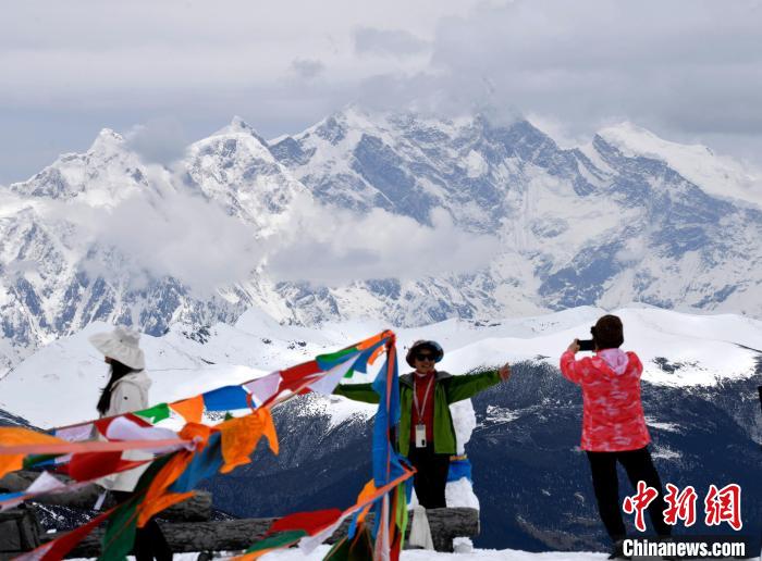 圖為5月14日，西藏林芝色季拉山觀景臺(tái)，游客與南迦巴瓦峰合影?！±盍?攝