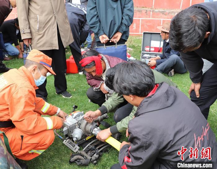 圖為森林消防員為護林員講解滅火裝備的使用方法?！〔际猩窒乐ш?供圖