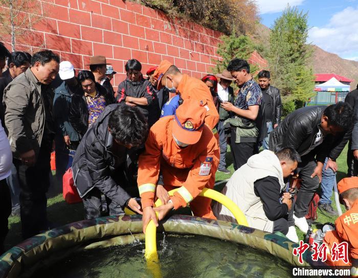 圖為森林消防員為護林員講解滅火裝備的使用方法?！〔际猩窒乐ш?供圖