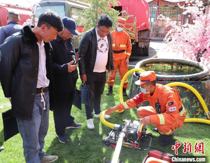 圖為森林消防員為護林員講解滅火裝備的使用方法?！〔际猩窒乐ш?供圖