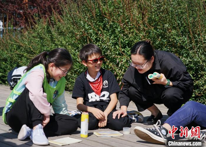 圖為小朋友在青海西寧湟水國家濕地公園內(nèi)認識植物并進行繪畫。　馬銘言 攝