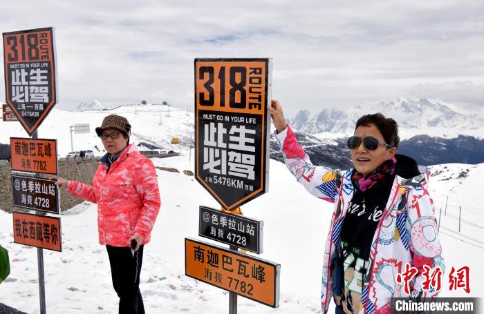 圖為5月14日，西藏林芝色季拉山觀景臺，游客與南迦巴瓦峰合影。　李林 攝