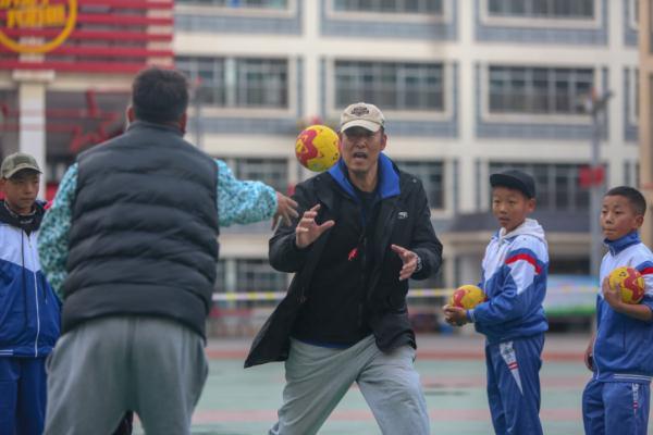 在高原上教孩子們打手球，“慢慢兒來，甭著急！”