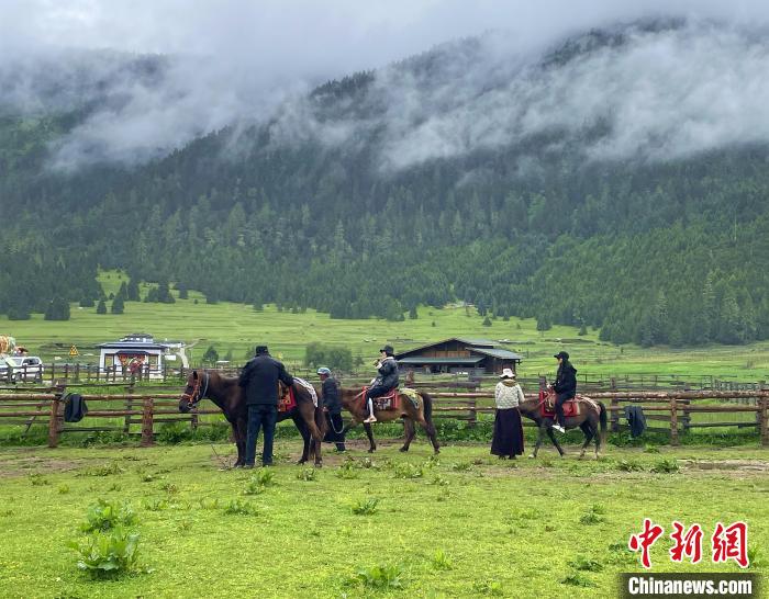 6月10日，游客在魯朗小鎮(zhèn)高山牧場(chǎng)景區(qū)體驗(yàn)騎馬。　冉文娟 攝