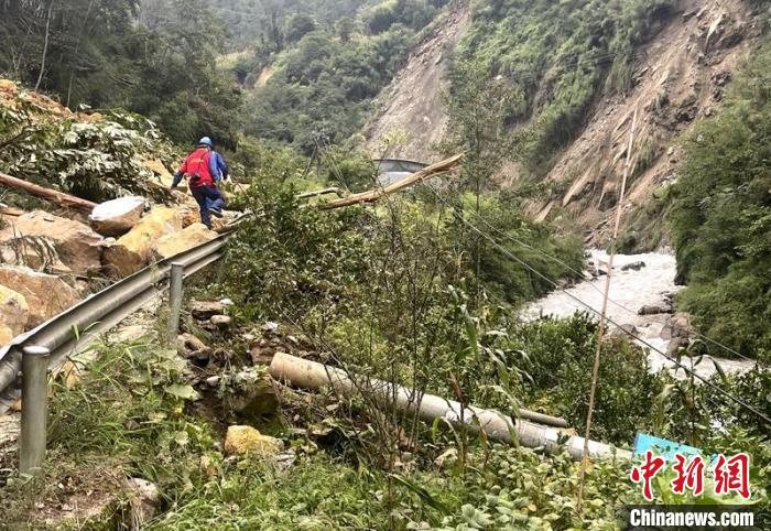 電力搶險人員快速通過危險路段，旁邊是受損的電力線路 四川電力供圖