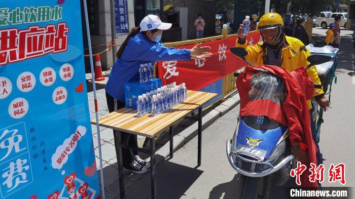 圖為近日，西藏自治區(qū)青年志愿者協(xié)會(huì)志愿者在拉薩街頭向快遞員送水。西藏自治區(qū)青年志愿者協(xié)會(huì) 供圖