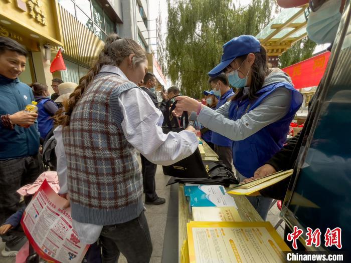 圖為志愿者為市民發(fā)放網(wǎng)絡(luò)安全宣傳手冊。　謝牧 攝