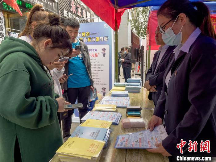 圖為工作人員正在向路過市民介紹國家反詐中心軟件的功能。　謝牧 攝