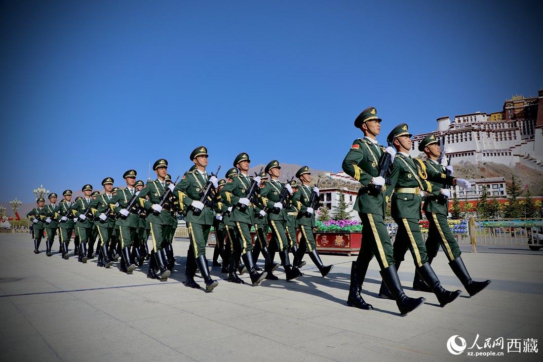 國旗護衛(wèi)隊隊員緊握鋼槍，踏著威武雄壯的步伐，走向國旗臺。人民網 次仁羅布攝