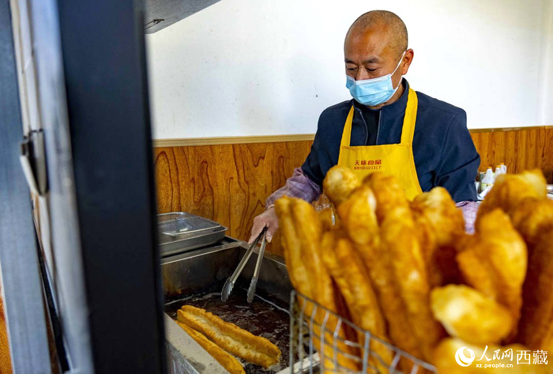 早餐店老板正在炸油條。人民網(wǎng) 次仁羅布攝