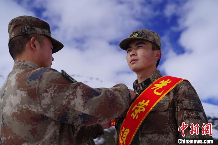 排長王朝偉(圖左)給退伍老兵佩戴大紅花?！∥鞑厣侥宪姺謪^(qū)某團供圖