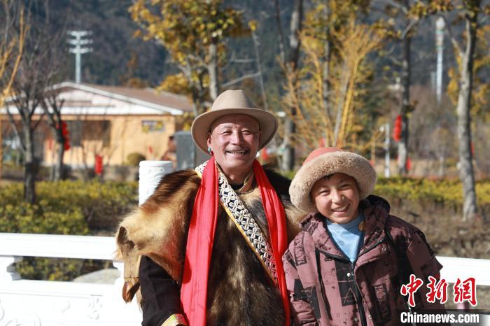 圖為林芝市巴宜區(qū)布久鄉(xiāng)仲果村村民桑杰與孫子一起參加藏歷新年活動?！埩?攝