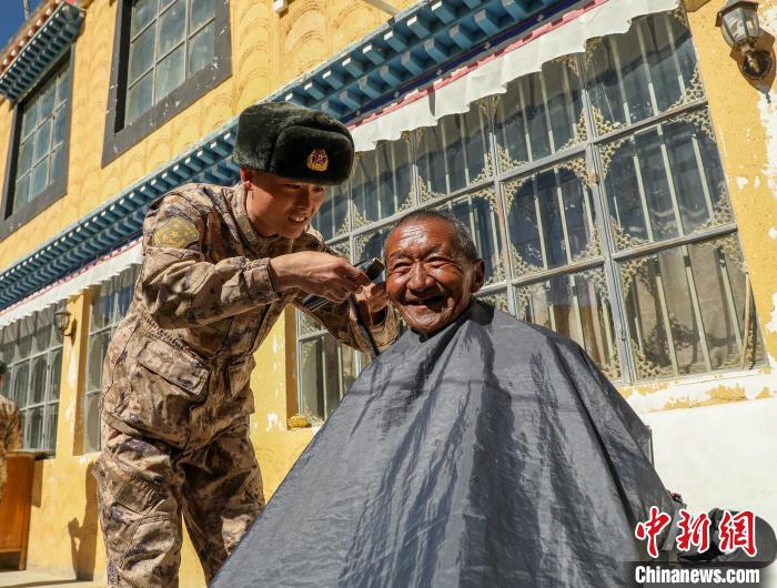 圖為阿里軍分區(qū)某邊防團官兵為駐地群眾理發(fā)迎藏歷新年。　旦增倫珠 攝