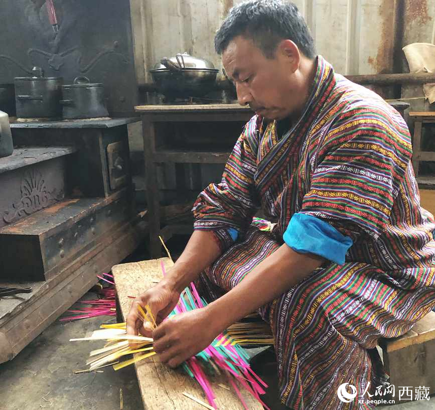 門巴族漢子愛明正在編織藤竹品。