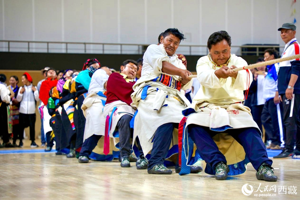 身著民族服裝的農(nóng)牧民選手在拔河比賽現(xiàn)場。