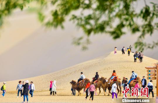 甘肅敦煌開啟旅游旺季數萬人“五一”暢游鳴沙山